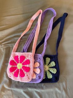 two crocheted purses sitting on top of a bed