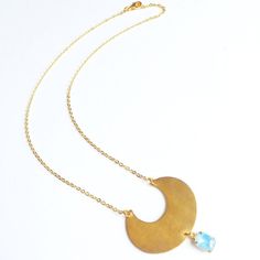 >>> Channel clarity and growth when you wear this moon statement necklace.>>> The moon is a symbol of subtlety, offering clarity from its reflected sunlight. >>> More specifically, crescent is derived from the Latin verb crescere, which means "to grow".>>> Whether for yourself or someone else, every order is creatively packaged and ready to gift.>>> A gold tone raw brass crescent pendant is hand punched and hangs with a glass aqua blue stone; 16k gold Bohemian Moon Phase Necklace For Festivals, Bohemian Crescent Necklace For Festivals, Gold Moon Necklace For Festivals, Handmade Bohemian Half Moon Necklace, Moon Phase Round Pendant Necklace For Festival, Bohemian Half Moon Necklace With Moon Phase, Bohemian Brass Moon Phase Necklace, Bohemian Half Moon Phase Necklace, Bohemian Crescent Necklaces For Jewelry Making