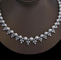 a necklace with white pearls and crystal leaves