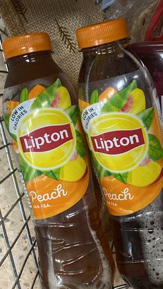 two bottles of lipton peach tea sitting on a shelf