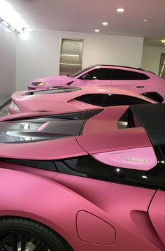 pink sports cars are lined up in a row