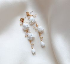 Expertly crafted with high quality materials, our MILANI Gold Floral Earrings are a stunning addition to any bridal ensemble. These long earrings feature gold filled accents and beautiful Austrian white opal crystal beads, adding a touch of elegance to any look. Elevate your style with these timeless and versatile statement pieces. - Handcrafted in my PA studio- Genuine white opal Austrian crystal beads- Polymer clay flowers- Yellow gold finish is pictured. Available yellow gold or rhodium (silv Gold Bridal Hair Comb, Bridal Statement Earrings, Flowers Yellow, Rose Gold Bridal, Polymer Clay Flowers, Clay Flowers, Opal Crystal, Gold Floral, Floral Earrings