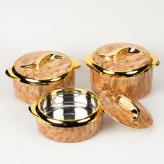 three gold - plated pots with lids on white background