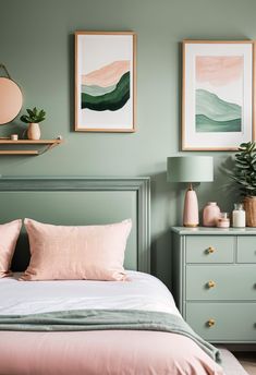 a bedroom with green walls and pink bedding, two framed pictures on the wall