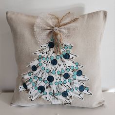 a decorative pillow with a blue and white christmas tree on the front, sitting on a table