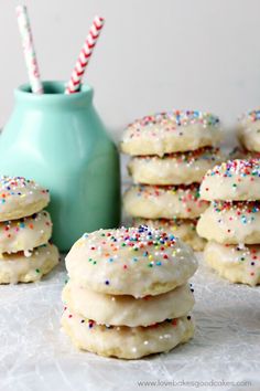 white frosted cookies with sprinkles and a blue vase on the side