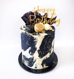 a black and white birthday cake with gold decorations