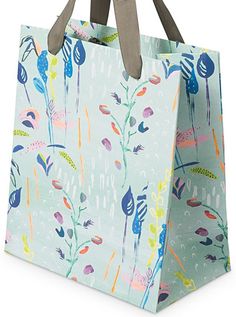 a blue shopping bag with colorful flowers and birds printed on the front, sitting against a white background