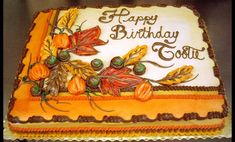 a birthday cake decorated with leaves and acorns