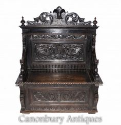 an ornate wooden bench with carvings on the top and bottom, sitting in front of a white background