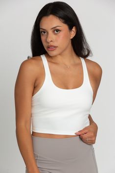 Our White Racerback Crop Tank features a slight cropped fit and racerback style that is the perfect go-to athletic top. It is complete with sweat-wicking material and a double layer, built-in-removable padded bra. 75% Nylon, 25% Spandex Built in / Removable Padding Model Details: Modeled in size: Small, Small Model Waist: 26, 30 Model Bust: 33, 34 Model Height: 5'3, 5'6 Sporty Racerback Crop Top With Built-in Bra, Medium Support Sports Bra With Built-in Bra, Sports Tank Crop Top With Built-in Bra, Everyday Scoop Neck Sports Bra, White Activewear With Built-in Bra For Everyday, Athleisure Scoop Neck Crop Top For Everyday, Everyday Athleisure Crop Top With Scoop Neck, Sporty High Stretch Crop Top With Built-in Padding, Sports Tops With Built-in Bra And Scoop Back