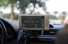 an electronic device mounted to the dashboard of a car, displaying aed 32 50