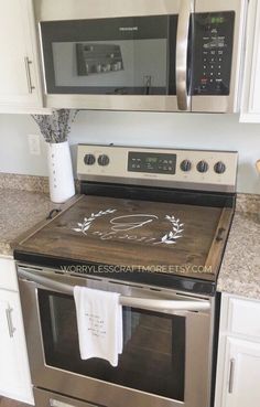 a kitchen with stainless steel appliances and white cabinets, including a microwave above the stove