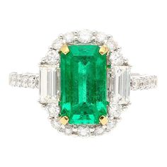 2.22 carat natural Colombian Emerald and Diamond Ring. Centering a lustrous emerald-cut emerald, measuring 10.3 x 6 MM, a desirable elongated shape that gracefully enhances the length of the finger.   The emerald is flanked by two baguette-cut diamonds, totaling 0.50 carats, and adorned by 24 round brilliant-cut diamonds, totaling 0.60 carats, creating a harmonious symphony of step and brilliant cuts. Set in smooth 18k white gold.   Ideal as an engagement ring or cocktail ring.   Ring Details: - Diamond Chandelier Earrings, Diamond Chandelier, Statement Rings Diamond, Platinum Diamond Rings, Colombian Emeralds, Diamond Cocktail Rings, Platinum Ring, Diamond Drops, Diamond Drop Earrings