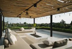 an outdoor living area with couches and lights