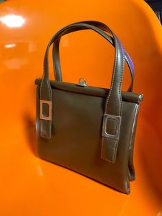 DESCRIPCIÓN: Bolso vintage MOD Brown, bolso de mujer de los años 60, bolso vintage, cierre plateado, pequeño estilo preppy de cuero, bolso de los años 60 con marrón. asa e interior marrón. El bolso tiene un bolsillo interior. Combinará perfectamente con tus outfits de los años 60.  CONDICIÓN: En muy buen estado de uso vintage por dentro y por fuera, consulte las imágenes. Falta uno de los detalles del asa de cuero marrón de la parte posterior; consulte las imágenes.  MEDIDAS Ancho 9" / 23 cm Alt Retro Satchel With Detachable Handle For Formal Use, Retro Formal Satchel With Detachable Handle, Vintage Satchel Shoulder Bag For Party, Elegant Vintage Brown Satchel Shoulder Bag, Retro Rectangular Evening Bag For Vintage Fashion, Evening Satchel Bag With Hasp Closure, Elegant Vintage Satchel Bag, Vintage Square Evening Bag For Formal Occasions, Retro Evening Satchel