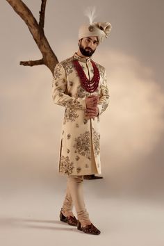 Frosted Almond Sherwani Set | Jatin Malik Introducing our masterpiece: the golden placement hand-embroidered sherwani. This exquisite sherwani showcases an intricate embroidery technique that utilizes various types of dabka and moti, creating a stunning visual impact. Paired with a wine hand-embroidered stole and matching safa, this ensemble epitomizes refined luxury and traditional excellence. Perfect for making a grand and elegant statement, this sherwani set is a testament to exceptional craftsmanship and timeless style. Included in purchase: Sherwani, Kurta, Churidar, Stole, Safa Product Specification Color: Golden Fabric: Linen silk Occasion: Engagement, Wedding, Bridal, Reception Style: Sherwani, Kurta, Churidar, Stole, Safa Care: Dry Clean Work: Hand Embroidery Customization options Reception Bandhgala With Zari Work, Naqshi Embroidered Straight Sherwani For Reception, Naqshi Embroidered Sherwani For Reception, Naqshi Embroidered Straight Kurta Sherwani For Reception, Unstitched Sherwani For Reception, Traditional Jamawar Churidar With Naqshi Detailing, Jamawar Churidar With Naqshi And Traditional Drape, Sherwani For Reception With Resham Embroidery And Straight Kurta, Reception Straight Kurta With Gold Embroidery