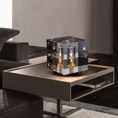 a coffee table with a mirrored box on top and two candles in the middle sitting on it