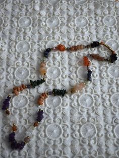 Vintage multicolored gemstone beaded necklace, featuring amethyst, carnelian, crystal quarts, onyx, agate. The necklace consists of one strand of stone chip beads, arranged by color with brass spacers between the different type of gemstones. Closes with screw barrel clasp at the back Era - 1980s Approx. Length (with clasp) - 24 inches / 61 cm Condition - Very good vintage condition, some dents on the stones! Vintage Gemstone Beads Jewelry For Healing, Artisan Multicolor Crystal Gemstone Necklace, Vintage Gemstone Necklace For Healing, Adjustable Multicolor Amulet Jewelry, Vintage Healing Gemstone Necklace, Unique Crystal Stone Necklaces For Healing, Bohemian Necklaces With Stones For Meditation, Bohemian Multicolor Gemstone Jewelry, Unique Crystal Necklaces For Healing