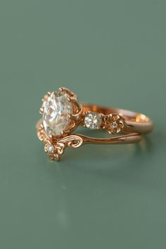 a close up of a ring with a diamond on the top and side stones in the middle