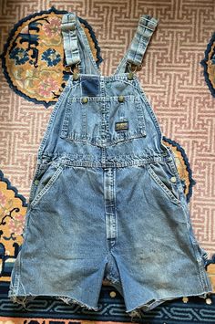 Very cute worn in Osh Kosh adult sized overalls. They have been made into cut offs. Original tag is worn and faded so I can't read what size it is.  All snaps, straps, buttons and zippers work as they should and are al there. Faded in spots. Worn in as you can see and super cute.  Measurements: Waist: front measurement across is about 17" across Bib front from top to bottom about 10" to waist band Rise: almost 13" long Button snap side waist to bottom of short measurement on the side: about 17" Vintage Light Wash Denim Overalls, Vintage Cotton Medium Wash Shortalls, Vintage Light Wash Overalls With Pockets, Vintage Denim Shortalls In Medium Wash, Vintage Denim Blue Cotton Shortalls, Vintage Denim Shortalls, Vintage Denim Overalls In Medium Wash, Vintage Style Medium Wash Denim Shortalls, Vintage Medium Wash Denim Shortalls