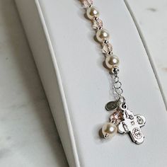 "This lovely First Communion bracelet is sure to be the perfect gift! A beautiful faith-based gift that doubles as a single-decade rosary. Made with ivory pears, vintage rose crystals, and sterling silver. Make it extra special by adding a sterling silver hand-stamped initial. J E W E L R Y ∙ D E T A I L S MATERIAL: Ivory Glass Pearls / Vintage Rose Crystals/ Sterling Silver / Pewter Charm / Silver Plated PENDANT SIZE: Cross: 1/2\" LENGTH: 5 1/2\" + 1/2\" Chain Extender CLASP STYLE: Sterling Sil Adjustable Silver Rosary For Mother's Day, Adjustable Rose Gold Rosary As Gift, Adjustable Rosary Bracelet For First Communion And Mother's Day, Elegant Rosary Bracelet With Miraculous Medal Gift, Elegant Rosary Bracelet With Miraculous Medal, Adjustable Rosary Bracelet With Miraculous Medal For First Communion, Personalized Adjustable Rosary Bracelet For Confirmation, Communion Gifts Girl, Initial J