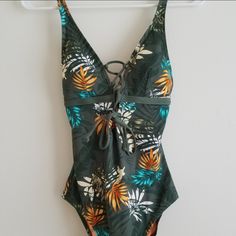 Moontide Women's One-Piece Swimsuit, Brand New With Tags Attached, Never Been Worn. Green And Orange Floral/ Palm Print, Lace Up Front And Tie In The Back. Padded/Lined Removable Cups. Adjustable Shoulder Straps. Hygienic Liner In Place. Usa Size 6. Designed In New Zealand. Make A Reasonable Offer On This Adorable Swimsuit!! Green One-piece Beachy Swimwear, Beachy Green One-piece Swimwear, Green One-piece Swimwear With Tropical Print, Green Tropical One-piece For The Beach, Green Tropical One-piece For Beach, Green Beachwear One-piece For Beach Party, Green Beachwear One Piece For Beach Party, Green One-piece Swimwear For Vacation, Green One-piece Beachwear For Beach Season