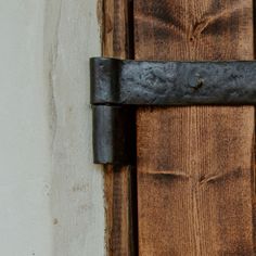 a close up of a metal handle on a wooden door