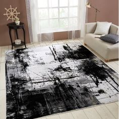 a black and white area rug in a living room with a couch, chair and window