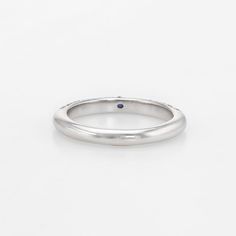 Elegant Adolfo Courrier stacking ring, crafted in 18 karat white gold.   One estimated 0.05 carat sapphire, accented with 36 estimated 0.01 carat round brilliant cut diamonds totaling an estimated 0.36 carats (estimated at G-H colour and VS2 clarity).    The house of Adolfo Courrier is a highly regarded Italian jeweller known for a brilliant contrast of colour and texture. The clean contemporary design of the ring is great worn alone as a simple band or stacked with your other rings.  The ring i Classic Sapphire Ring In 14k White Gold, Modern Diamond Engraved Ring With Polished Finish, Classic Sapphire Birthstone Ring, Classic Sapphire Halo Ring, Luxury White Gold Sapphire Ring With Vvs Clarity, Classic Stackable Rings With Diamond Accents, Classic Diamond Stackable Rings With Round Band, Formal Round Band With Tension Setting, Formal Round Band With Tension Setting Jewelry