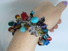 This is a great multi color cha cha bracelet.   It is full of all kinds of gemstones and glass beads.   This  bracelet takes me 2 hours to make.  Each bead cluster is hand-formed and attached one by one to a durable silvertone chain. It's a chunky bracelet and looks great with jeans.  It has a large durable toggle clasp that makes it easy to put on yourself.  Bracelet is available 7", 7 1/2", 8' or 8 1/2"  inches long.   Ideally the length of the bracelet should be ordered 1/2 inch longer than t Stretch Bracelet With Large Czech Glass Beads, Adjustable Multicolor Czech Glass Stretch Bracelet, Hand-strung Adjustable Czech Glass Stretch Bracelet, Multi-strand Czech Glass Jewelry With Large Beads, Hand-strung Bohemian Czech Glass Stretch Bracelet, Multicolor Bracelet, Large Bracelet, Chunky Bracelet, Chunky Bracelets