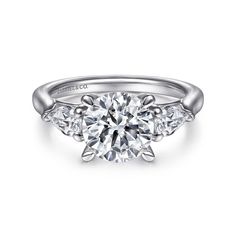 a three stone diamond engagement ring on a white background