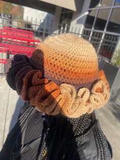 a close up of a person wearing a crocheted hat with braids on it