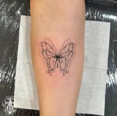 a black and white butterfly tattoo on the right leg, with lines drawn across it