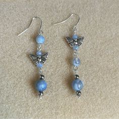 the earrings are made with glass beads and silver butterfly charmes, which hang from sterling earwires