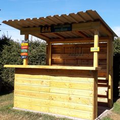 a small wooden bar in the middle of some grass