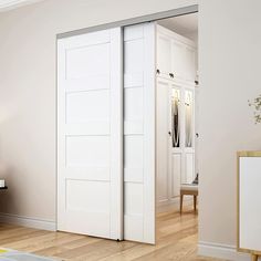 an open white door in the middle of a living room with hardwood floors and furniture