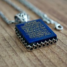 PENDANT: Lapis Lazuli(natural) METAL : .925 Sterling Silver DIMENSIONS : 24 x 22 mm CHAIN: Byzantine King chain METAL : .925 Sterling Silver LENGHT: 55 cm - 21inches THICKNESS: 2 mm What is engraved on the stone? There are certain verses in the Quran that were revealed by Allah to help guide us. They are so powerful that by simply reciting them you, your home and your family would be protected from many evils and from the powers of Shaitan.This verse is ayah 255 from Surah Baqarah commonly refer Spiritual Sterling Silver Etched Necklaces, Spiritual Etched Sterling Silver Necklaces, Spiritual Etched Sterling Silver Necklace, Symbolic Square Pendant Necklace With Engraving, Spiritual Carved Sterling Silver Jewelry, Spiritual Sterling Silver Necklace With Engraving, Spiritual Sterling Silver Engraved Necklace, Traditional Jewelry With Engraving Option As Gift, Traditional Jewelry With Engraving Option For Gift