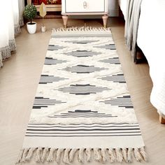 a white rug with black and white designs on it next to a dresser in a bedroom