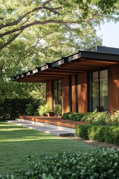 a modern house with wooden sidings and large windows in the front yard, surrounded by trees