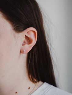 a close up of a person wearing some kind of earring on their left ear