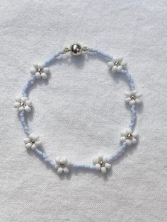 "Handmade, 6.5 inch, delicate light blue beaded bracelet. Woven into a Daisy Chain pattern and perfect for all ages. Beautiful for layering and on its own as well! Makes a great gift and is perfect for friendship bracelets! Every bracelet is finished with a magnetic clasp for easy wearing. Primary color refers to the color in the center of the Daisy. The \"Clear\" primary color can be glow-in-the-dark if requested. If selecting a non-metallic primary color, please specify in the personalization Dark Blue Beaded Bracelet, Daisy Chain Pattern, Trendy Summer Jewelry, Light Blue Jewelry, Daisy Chain Bracelet, Light Blue Bracelet, Blue Bracelets, Tiny Bead Bracelet, Friendship Bracelets With Beads