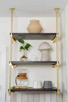 three shelves with vases and other items on them