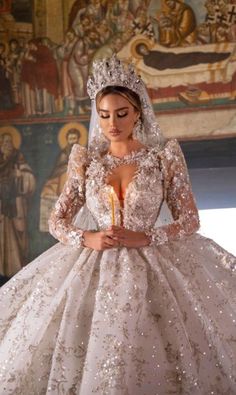 a woman in a wedding dress holding a candle