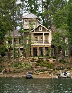 a boat is parked in front of a house on the water with trees around it