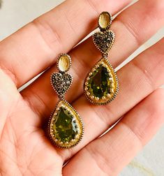 A beautiful vintage pair of drop earrings made of 9K yellow gold and silver set in three parts. On the top two oval-shaped studs, in the middle two hearts covered with rose-cut natural brown diamonds, and on the bottom two artificial green stones in teardrop shape. A lovely pair of earrings with a slight dangle.  In this pair of earrings, the brown diamonds are natural in rose cut and the green stones are synthetic yet very impressive.  Artificial gemstones are popular in jewelry manufacture sin Green Diamond Accent Drop Earrings, Green Diamond Accented Drop Earrings, Green Drop Earrings With Diamond Accents, Vintage Gold Gemstone Earrings, Gold Oval Earrings With Diamond Accents, Oval Gold Earrings With Diamond Accents, Vintage Gold Earrings With Rose Cut Diamonds, Victorian Gold Gemstone Earrings, Vintage Teardrop Jewelry With Diamond Accents