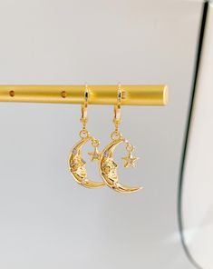 Radiate celestial elegance with The Moon Goddess Huggie Earrings. These earrings capture the allure of lunar beauty in a mesmerizing design. Meticulously crafted, the mini moon and goddess charms exude a sense of ethereal grace and power. The huggie style ensures a secure fit, promising comfort throughout the day. Whether you're drawn to cosmic mystique or seek unique accessories, these earrings make a statement. Perfect for both casual outings and special occasions, they infuse your ensemble wi Gold Single Moon-shaped Earring, Dainty Half Moon Charm Earrings, Dainty Half Moon Earrings With Moon Charm, Mystical Gold Earrings With Sun And Moon Design, Gold Half Moon Celestial Earrings, Gold Moon-shaped Earrings, Dainty Single Moon Earring, Dainty Moon Shaped Single Earring, Moon Charm Hoop Earrings In Celestial Style