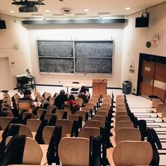 an empty classroom with chairs and a blackboard