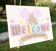 a welcome sign with a castle and fireworks in the background on a wooden easel