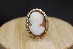 Precious Bezel set Shell cameo ring. Set in 10k yellow gold. Vintage made before middle of century. Marked BDA - Budlong, Dockert & Armstrong Condition: shows signs of wear consistent with old age. Details 3.7grams total weight 10k gold and carved shell 20mm by 15mm rectangle cameo Cameo 14k Gold Round Jewelry, Cameo 14k Gold Ring, Antique 14k Gold Cabochon Rings, Cameo 14k Gold Rings For Collectors, Cameo 14k Gold Rings For Anniversary, Gold Cameo Signet Ring Collectible, Gold Signet Ring With Cameo Collectible, 14k Gold Cameo Round Jewelry, 14k Gold Cameo Ring Fine Jewelry